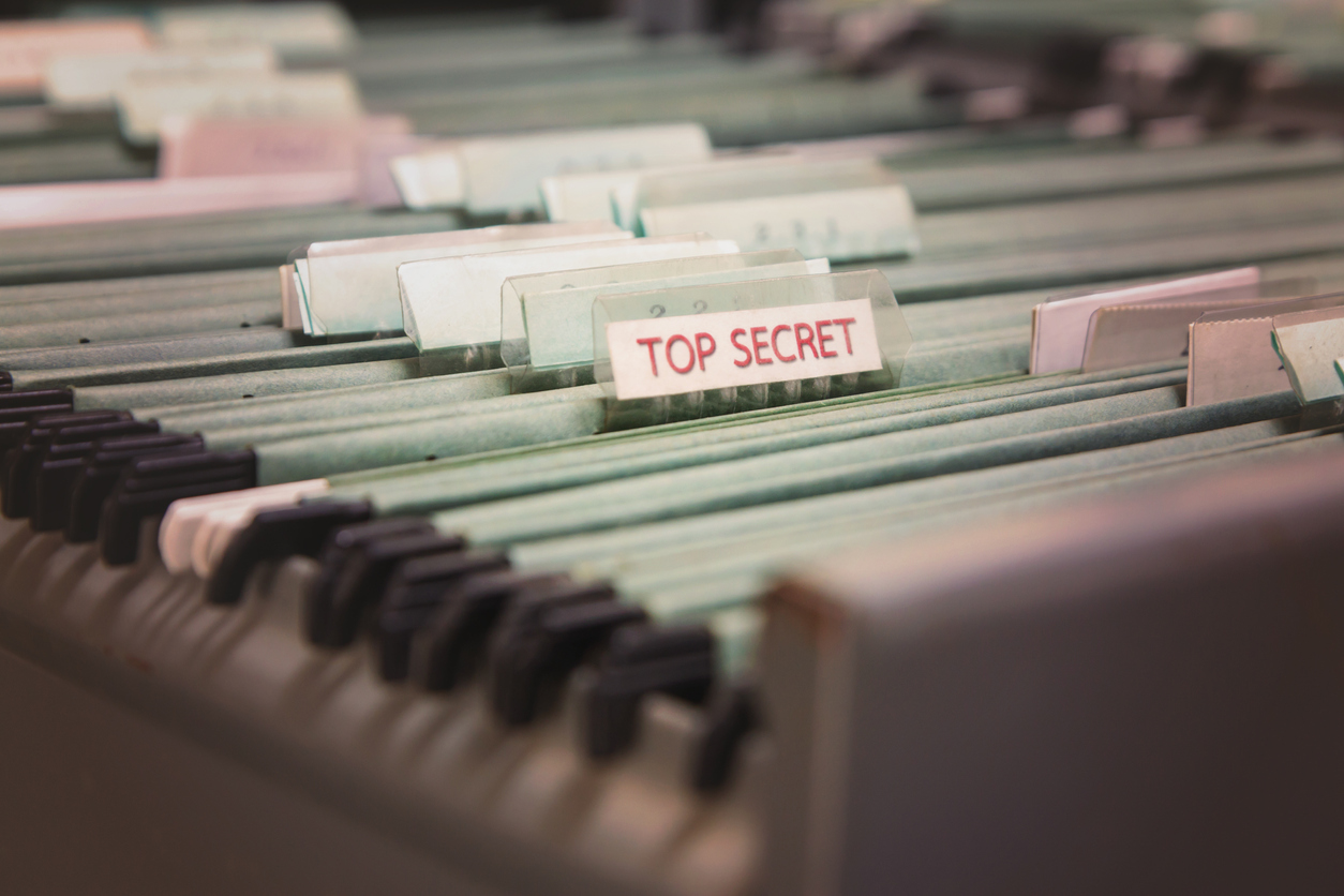 Files in a filing cabinet, with one tab indicating the Top Secret files. Easier access to higher clearances is one of the benefits of having a security clearance.