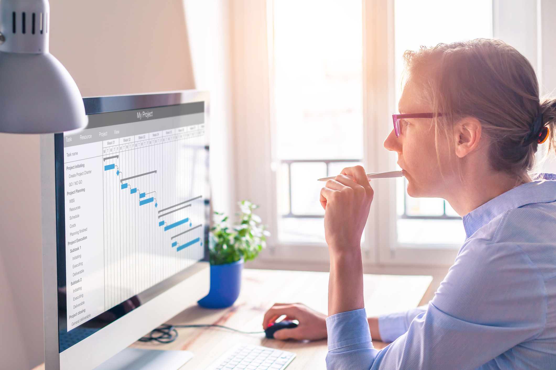 A woman contemplating a project management dashboard. While it takes time and effort, it's worth learning how to develop a technology roadmap.