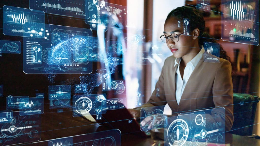 Business woman in front of computer with digital landscape.