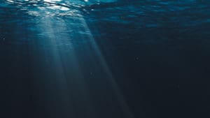 Underwater acoustic testing equipment represented by light rays in an underwater landscape