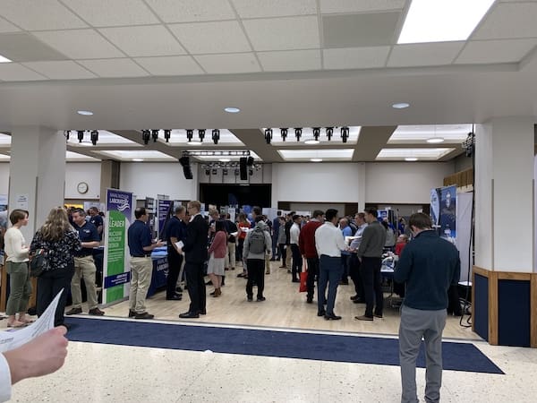 A STEM Career Fair at a university with students and employers standing around near booths